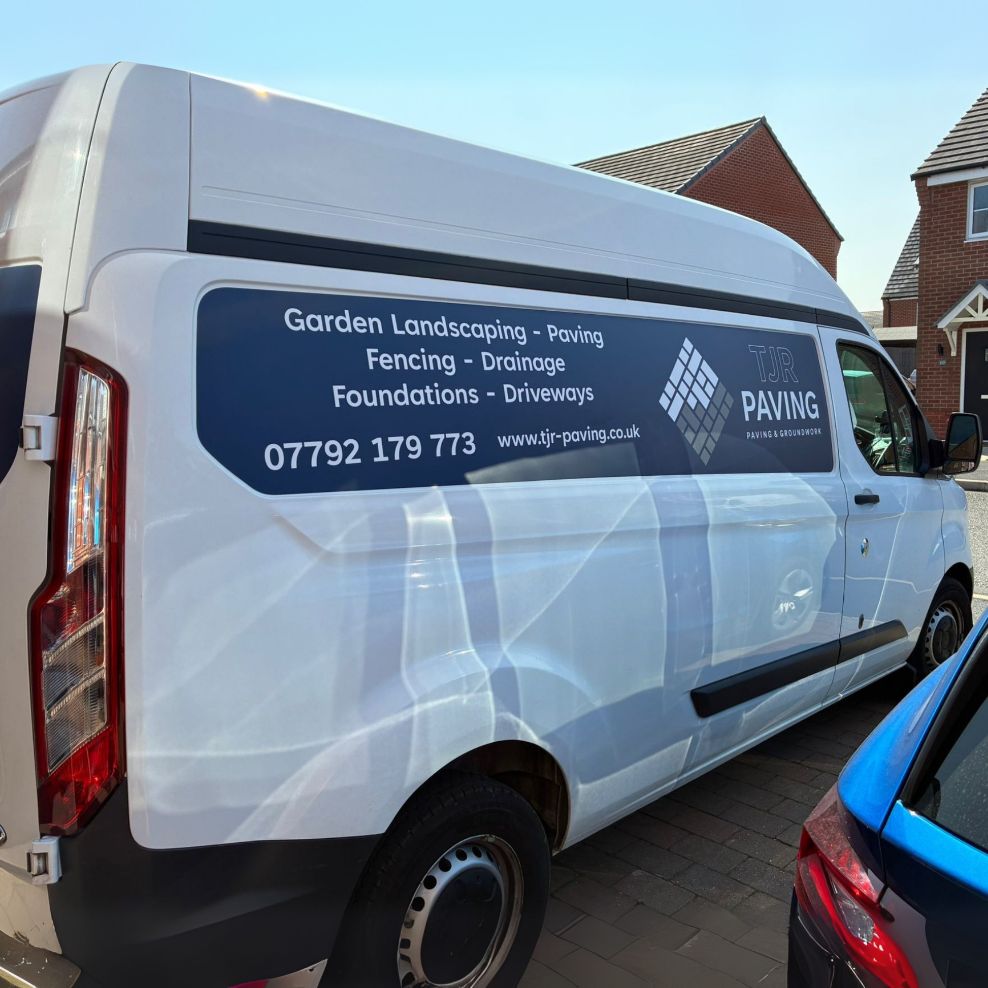 White van with TJR Paving advertisement on a residential street